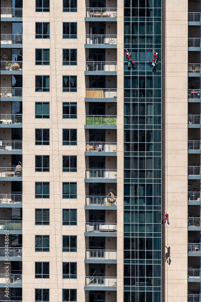 group of climbing workers cleaning a skyscraper window