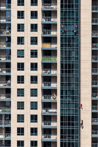 group of climbing workers cleaning a skyscraper window