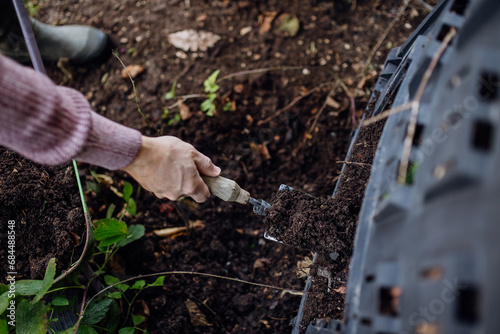 Wallpaper Mural Girl removing compost from a composter in the garden. Concept of composting and sustainable organic gardening. Torontodigital.ca