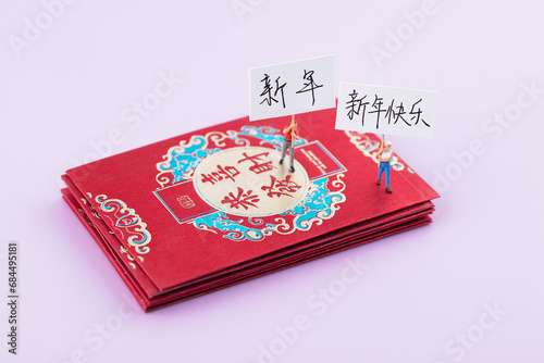 Raise a sign on the miniature concept red envelope to celebrate the New Year.The Chinese characters in the picture mean "Congratulations on getting rich" and "Happy New Year"