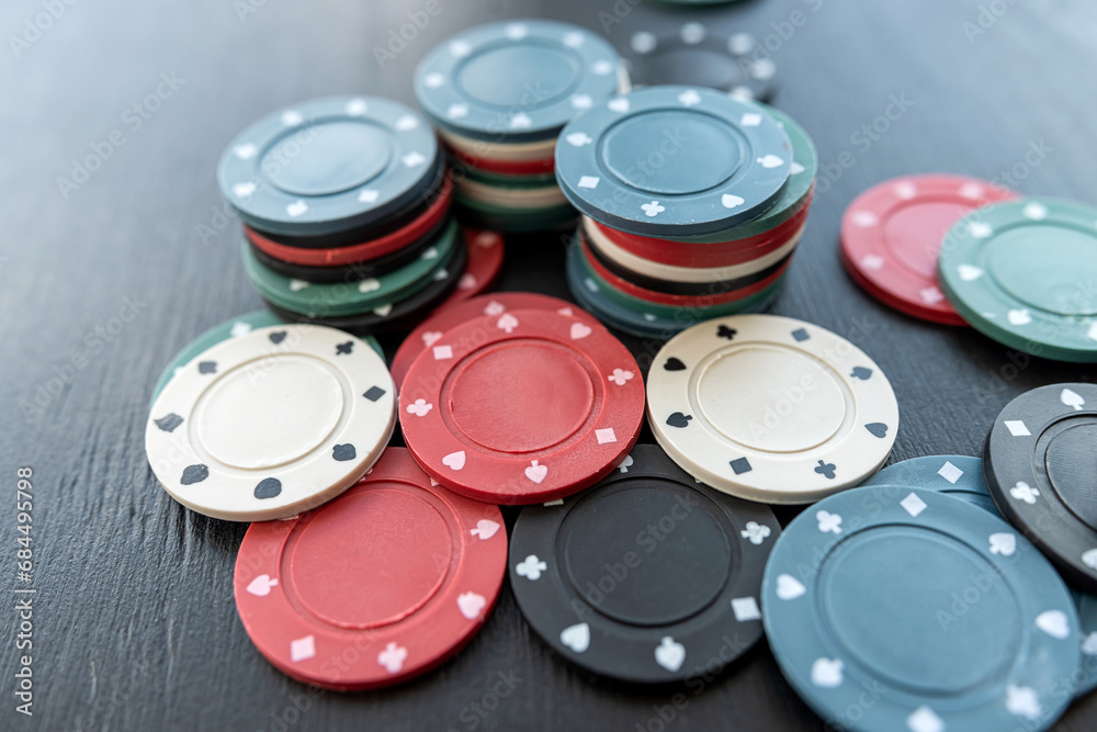 Colorful different value poker chips on black casino table, win after game Colorful different value poker chips on black casino table, win after game