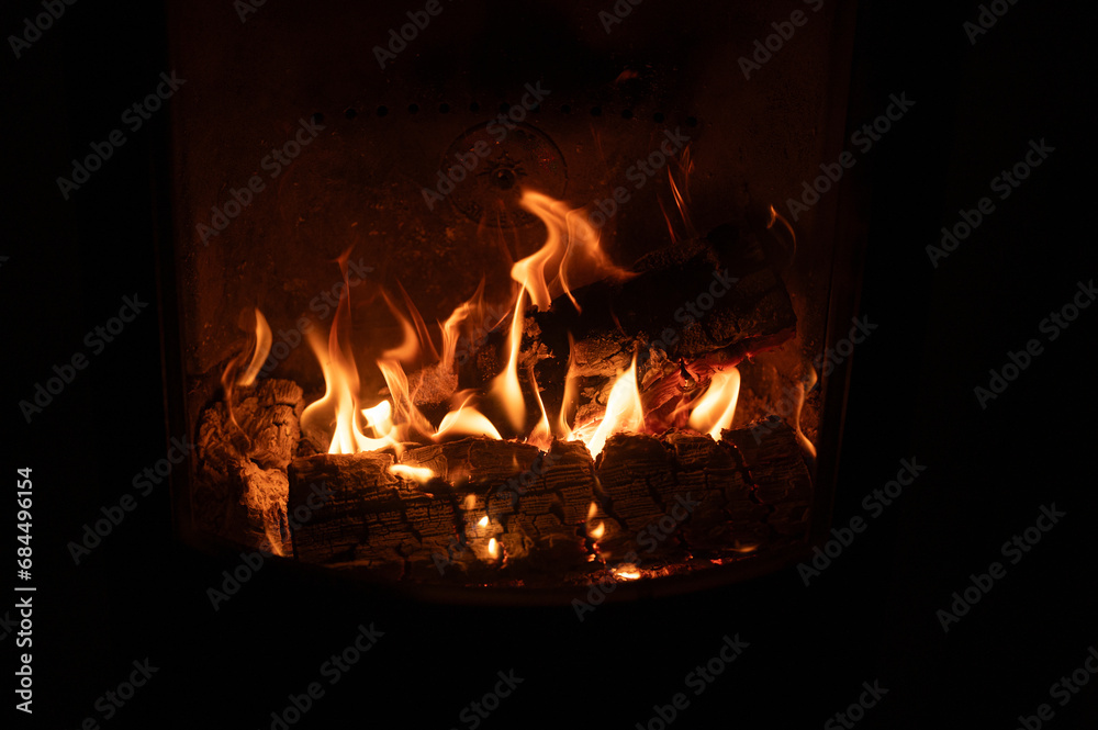 open flames and firewood in fireplace behind glass open flames and firewood in fireplace behind glass