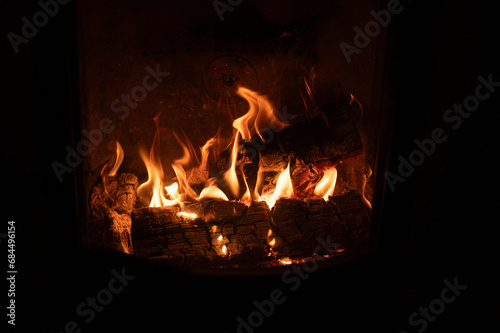 open flames and firewood in fireplace behind glass