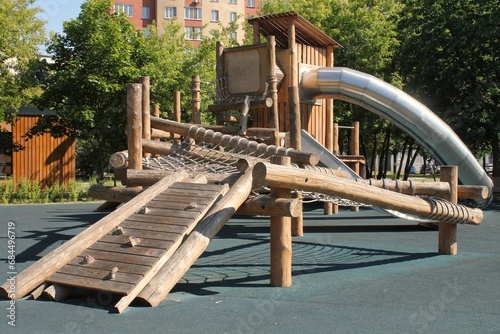 Wooden modern ecological safety children outdoor playground equipment in public park. Nature architecture construction playhouse in city. Children rest and childhood concept. Idea for games on air. photo