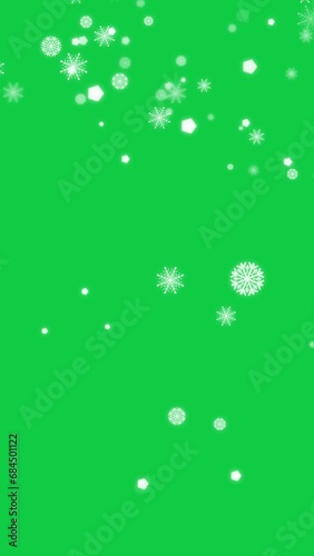 4K vertical. particle animation of white snowflake, snow crystal falling down decoration for winter season isolated on chroma key green screen background for overlay motion graphic