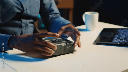 Tech content creator filming technology review of newly released V mount battery, unpacking it and presenting specifications to audience. Influencer showing charging device to subscribers