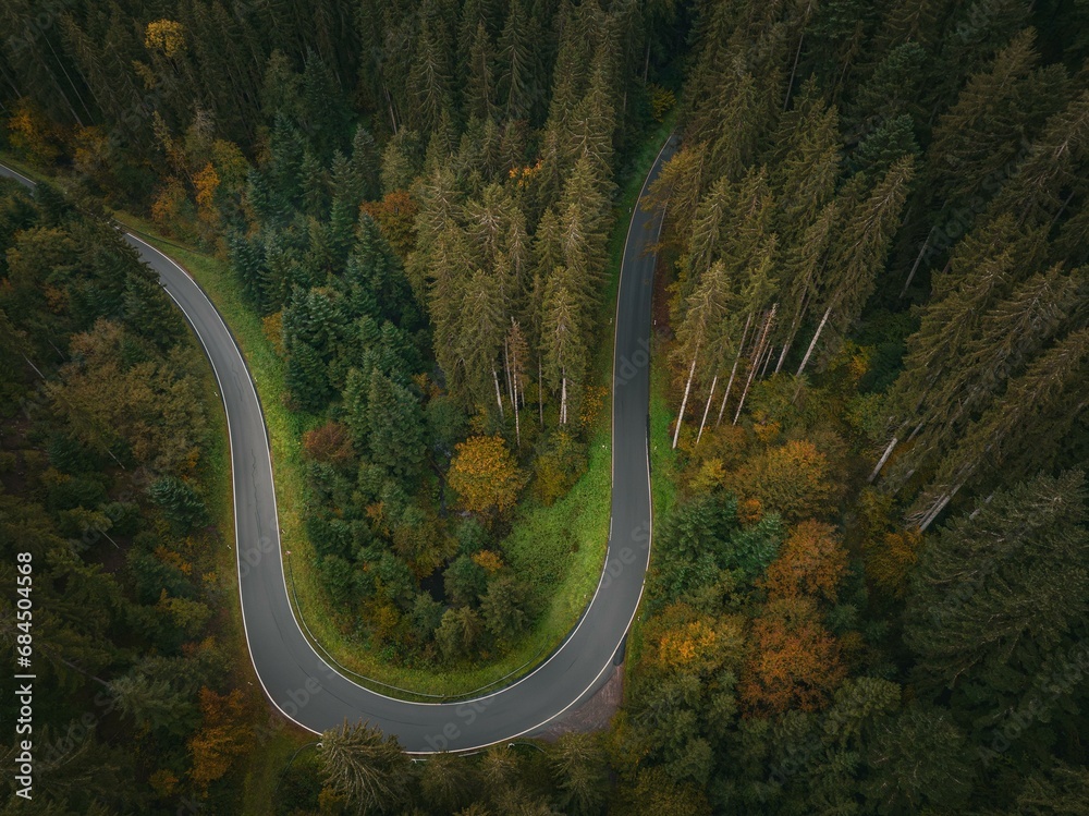 Aerial view of a road with an S-curve through the autumn forest, Black Forest, Rotfelden, Germany, Europe