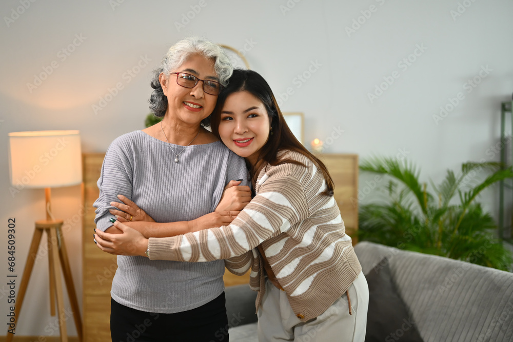 Loving young woman embracing happy senior mother with tenderness and care Loving young woman embracing happy senior mother with tenderness and care