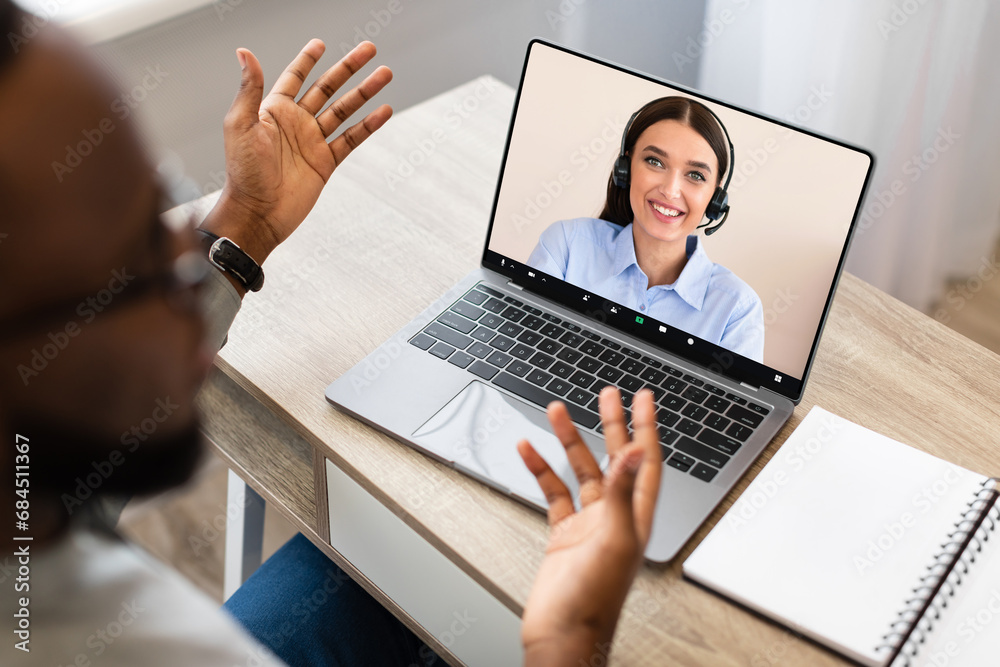 African Businessman Talking To Woman Assistant, Using Laptop In Office African Businessman Talking To Woman Assistant, Using Laptop In Office