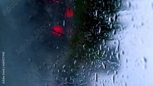 Vertical footage of raindrops on the window and cars passing