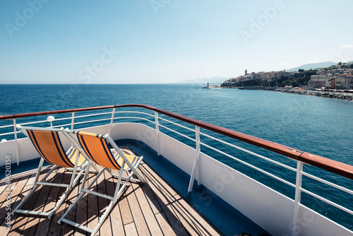 France, Haute-Corse, Deck chairs on bow of ferry sailing toward coast of Corsica island photo