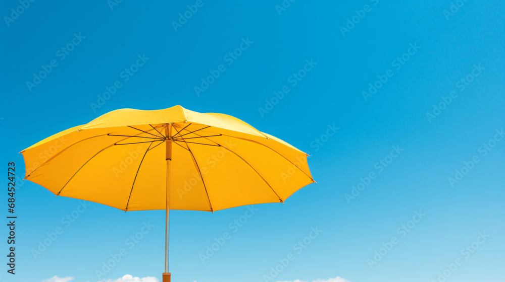 A yellow umbrella against a blue sky with a pole