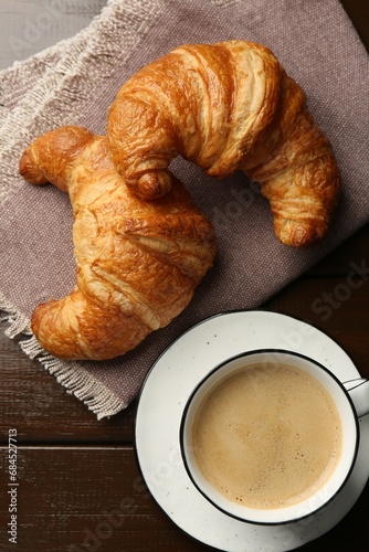 Delicious fresh croissants and cup of coffee on table, flat lay