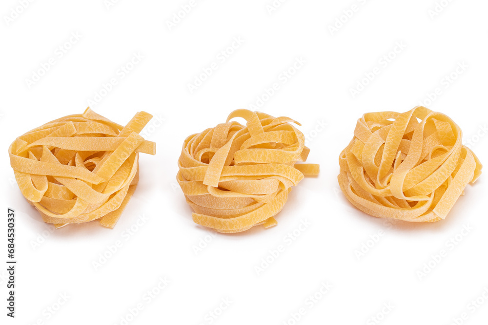 Three Classic Italian Raw Egg Fettuccine - Isolated on White Background. Dry Twisted Uncooked Pasta. Italian Culture and Cuisine. Raw Golden Macaroni Pattern - Isolation Three Classic Italian Raw Egg Fettuccine - Isolated on White Background. Dry Twisted Uncooked Pasta. Italian Culture and Cuisine. Raw Golden Macaroni Pattern - Isolation