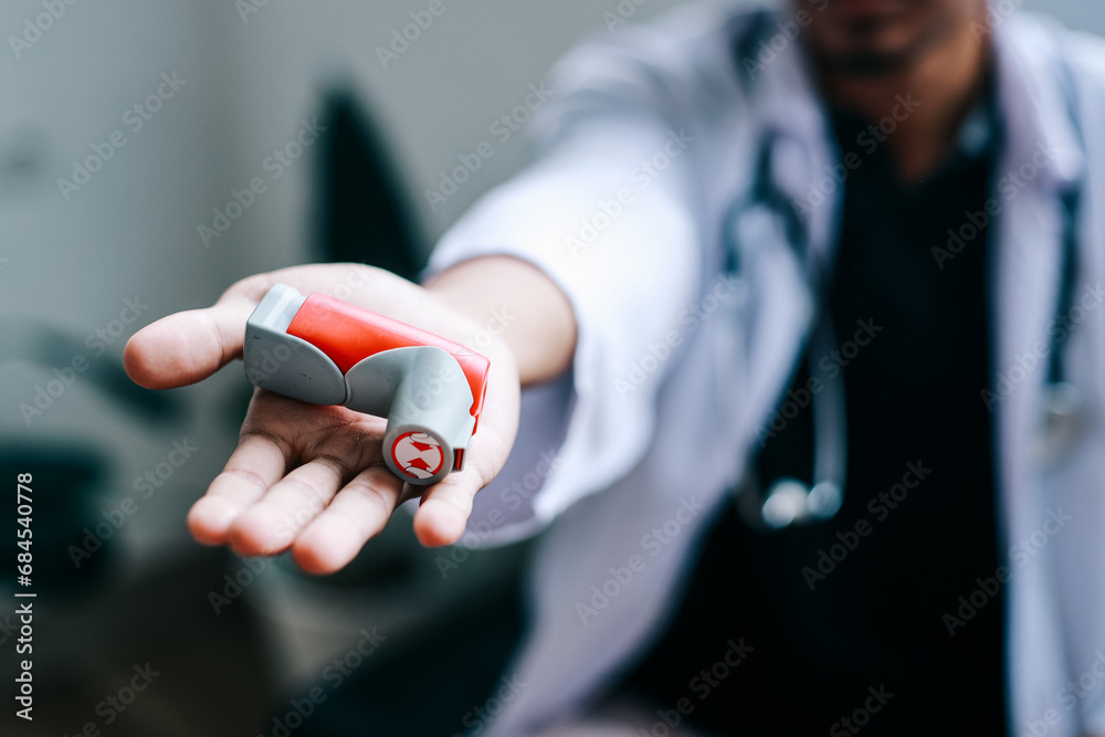Male doctor showing asthma inhaler on palm hand. Portable medication.  - obrazy, fototapety, plakaty 