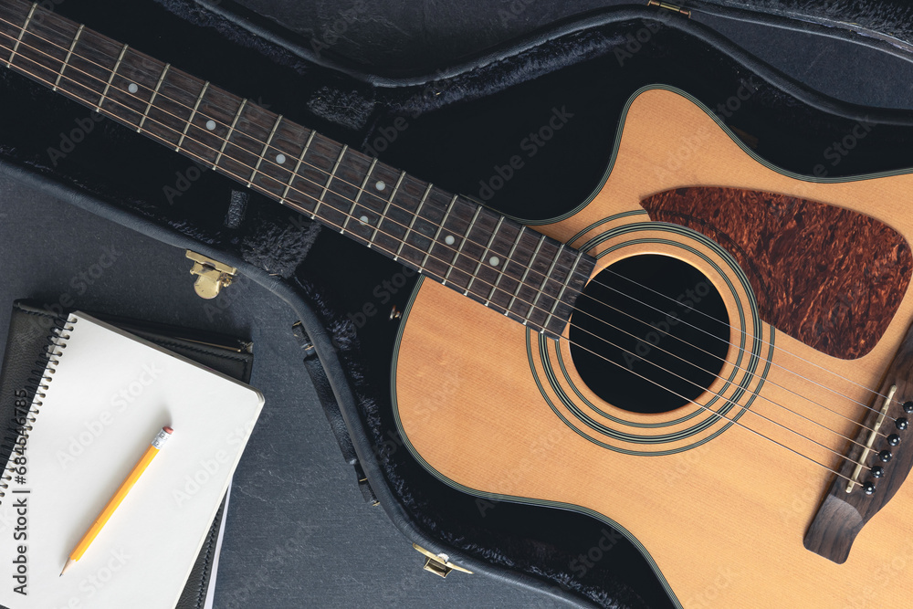 Fototapeta premium Acoustic guitar and notepad with pencil, top view.