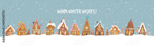 Christmas greeting card with cute gingerbread houses on blue background with snowflakes. Christmas village drowning in snow. Vector illustration
