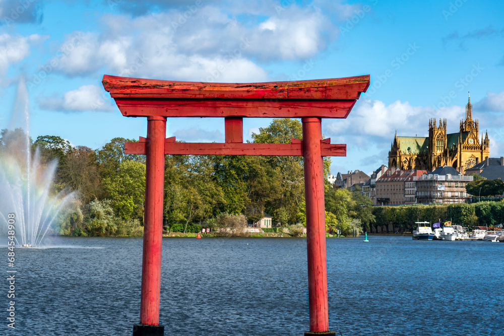 Japanese Torii gate in Metz at the plan d’eau with the Saint Stephen cathedral in the background