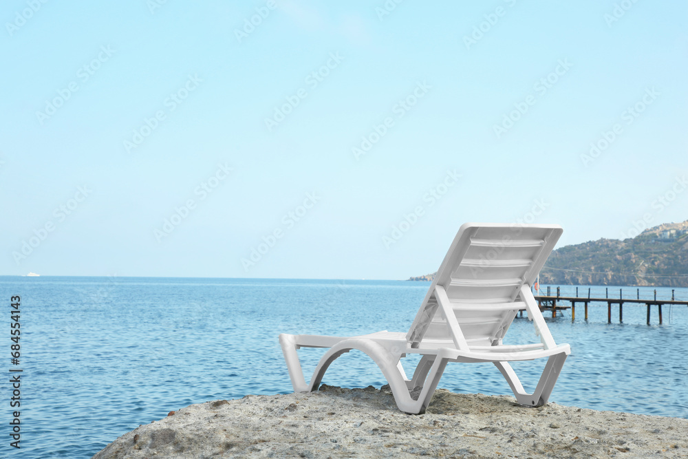 One lounge chair on beach near sea. Space for text