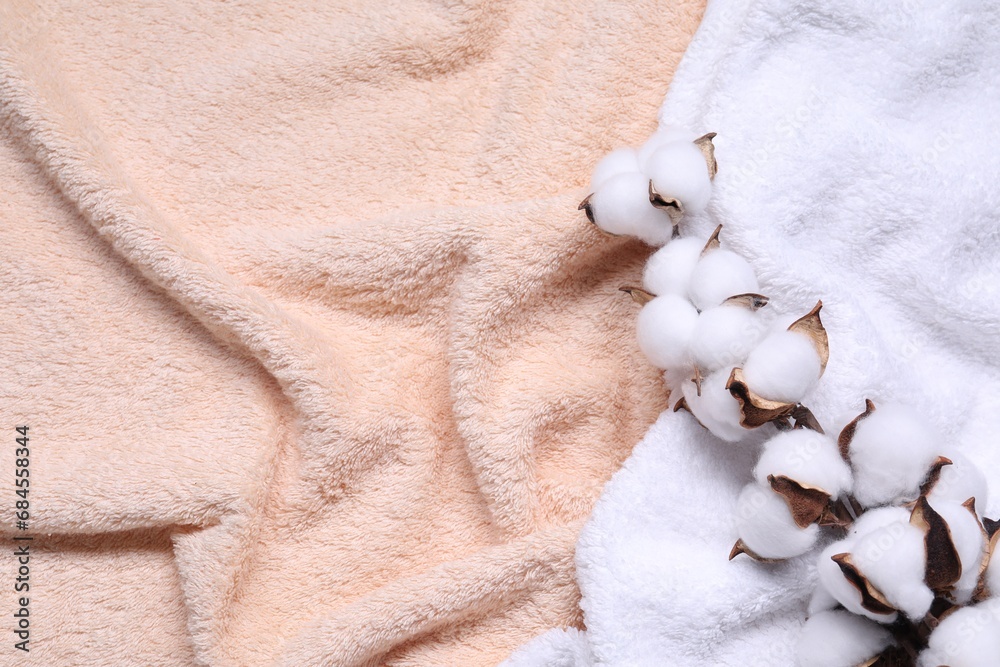 Cotton branch with fluffy flowers on terry towel, top view. Space for text Cotton branch with fluffy flowers on terry towel, top view. Space for text