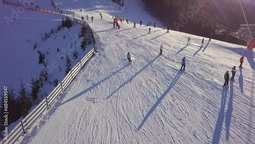 Many Skiers are Driving Along the Ski Slope. Drone View