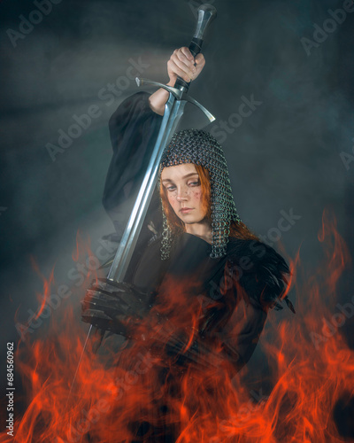 Portrait of a fighting Valkyrie with a sword in a plate cap