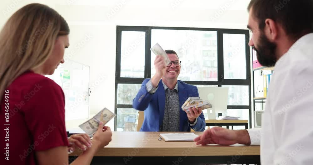 Sad business woman and man sitting at work desk and receiving little cash from boss