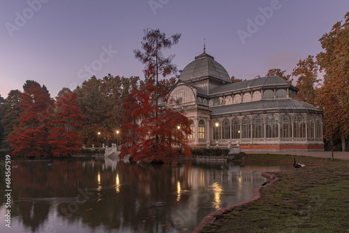 views of the glass palace of the parque del retiro in madrid in autumn with its pond in front of it. glass palace of the parque del retiro. parque del retiro in autumn. retiro park