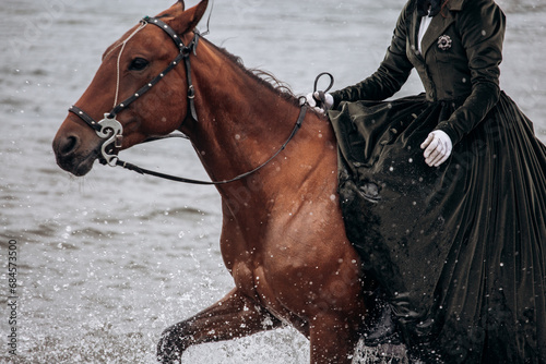 A beautiful girl rides a horse in the rain on the river.