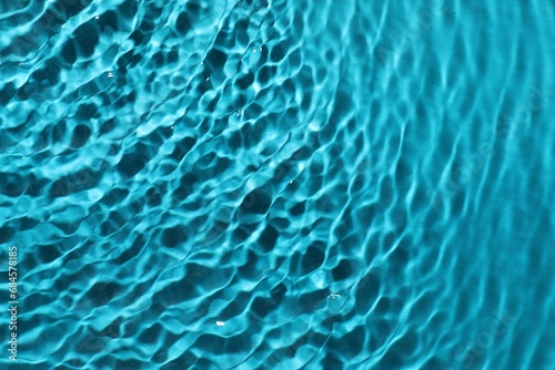 Rippled surface of clear water on light blue background  top view