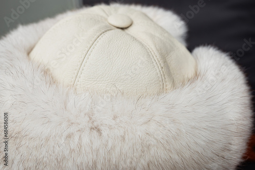 white hat close-up. fur moves from the breath of air, part of a fur coat made of natural white fox fur, close-up of arctic fox fur used in the manufacture of clothing