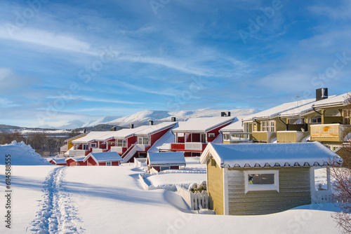 Norwegian traditional houses of Troms in the winter. Snowy arctic city with colorful houses and port