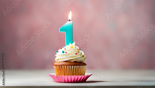 Birthday cupcake with lit birthday candle Number one for one year or first anniversary photo