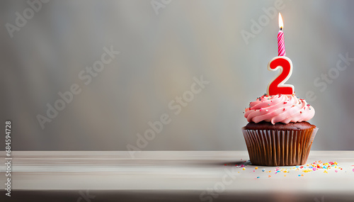 Birthday cupcake with lit birthday candle Number two for two years or second anniversary photo