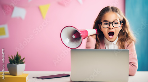 Girl child sit at her laptop and yells into a megaphone on pink background. Distance learning, discounts on online courses for kids, promo, online school promotion. photo