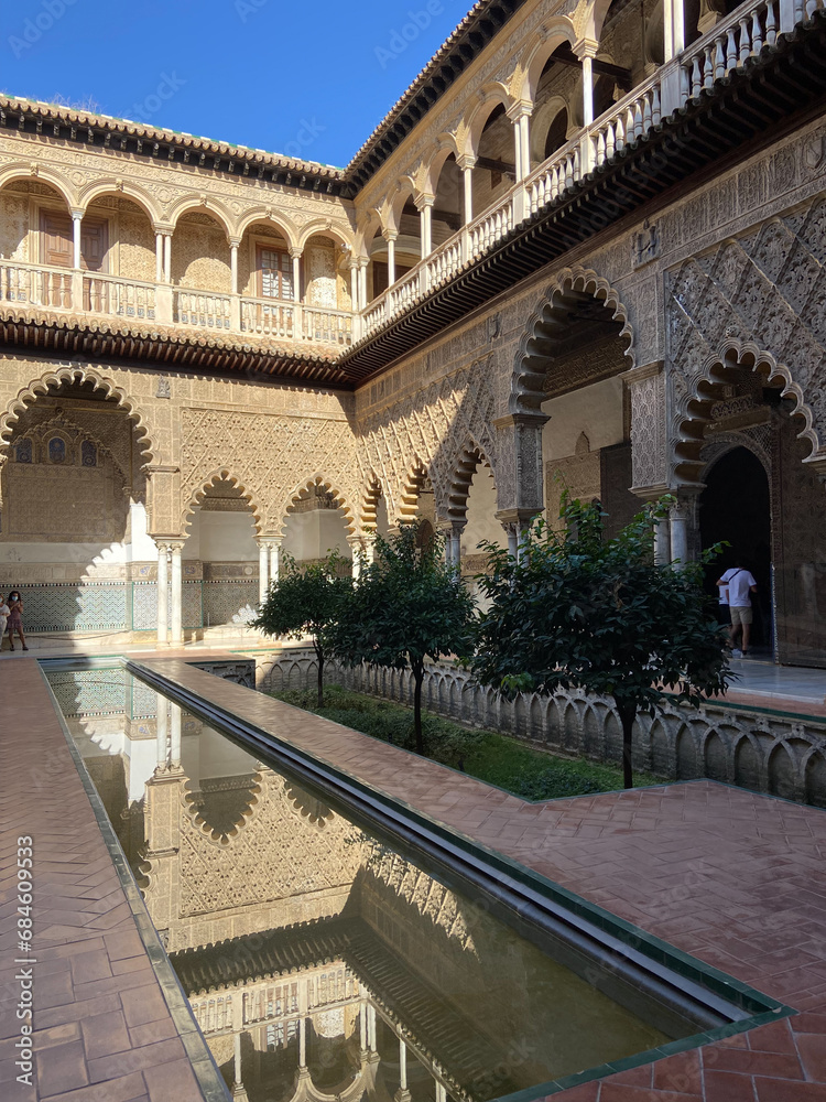 Fototapeta premium Seville, Spain, September 12, 2021: Royal Palace of Seville (Real Alcazar). The Maidens Courtyard. The Mudejar of Pedro I on the ground floor and the Renaissance of the first monarchs.