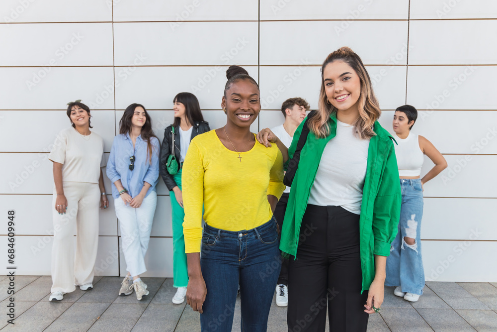 Fototapeta premium Happy diverse friends standing near wall