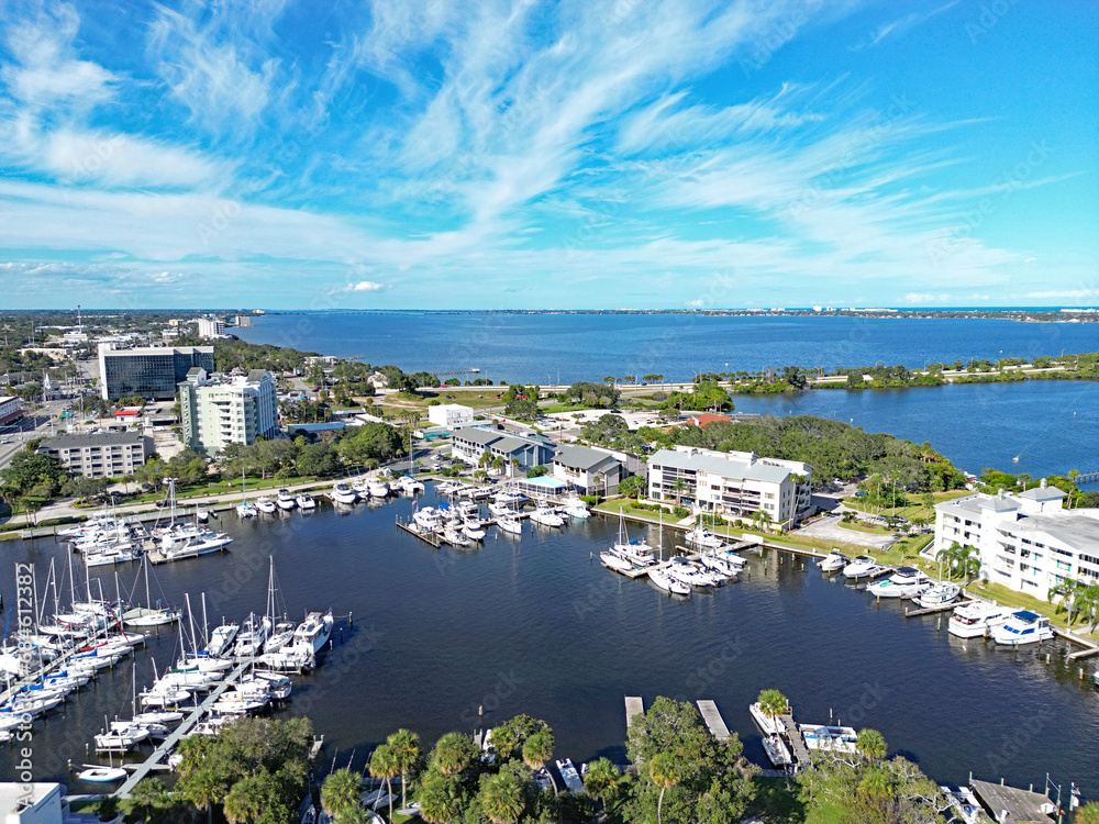 Fototapeta premium Aerial view of the yacht harbor basin with boats and nearby condos in historic downtown Melbourne along Florida's Space Coast in Brevard County