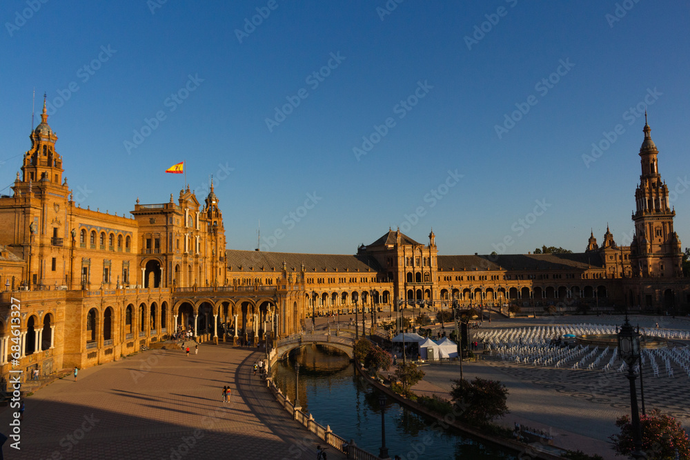Seville, Spain, September 11, 2021: The Spanish Steps in Seville or 'Plaza de España', where the main building of the Ibero-American Exhibition of 1929 was built. Spanish flag at sunset.