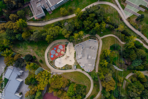 Amazing aerial view of the skate park in Santo Tirso in Portugal with many skaters and BMX bikers on it. The Geao Urban Park with high school building in background. photo