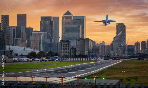 Obraz na płótnie Panoramic view of the London skyline with Canary Wharf district and the runway of the City Airport in front during sunset time w salonie