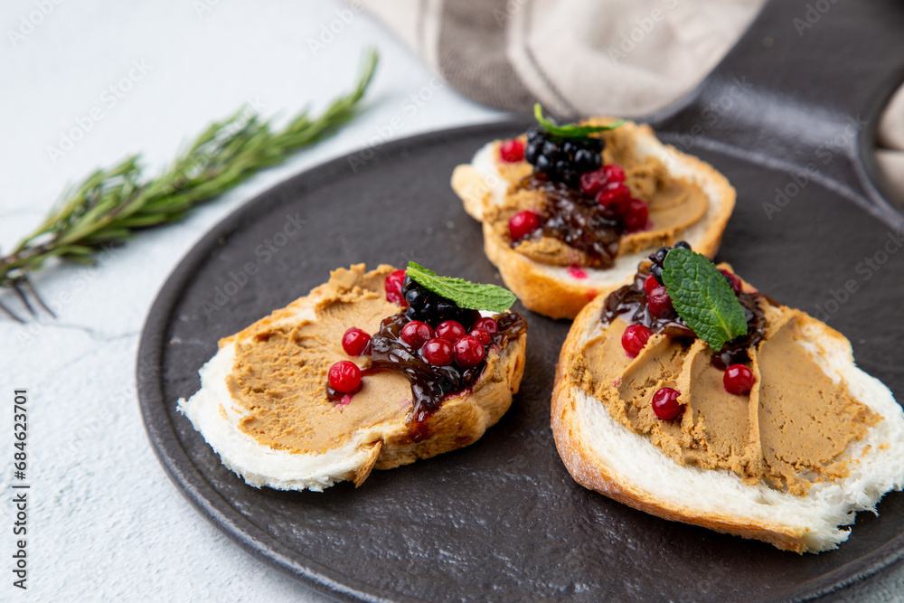 canapes with pate, mint leaves and berries, side view