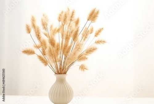 a vase of dried dried grass are sitting on a white surface