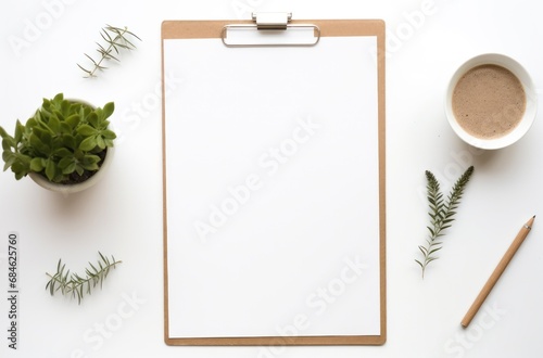 a white plate, clipboard, phone, computer and plant,