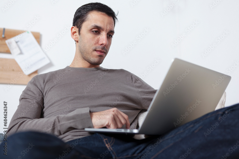 Young man using laptop pc and working from home Young man using laptop pc and working from home