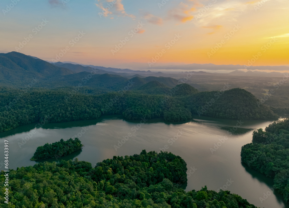 Beautiful landscape of green mountains and lake in the morning with sunrise sky. Nature landscape. Watershed forest. Water and forest sustainability concept. Aerial view of mountain with green trees.