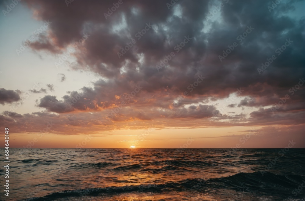 Sunset horizon over ocean with waves and cloudy sky.
