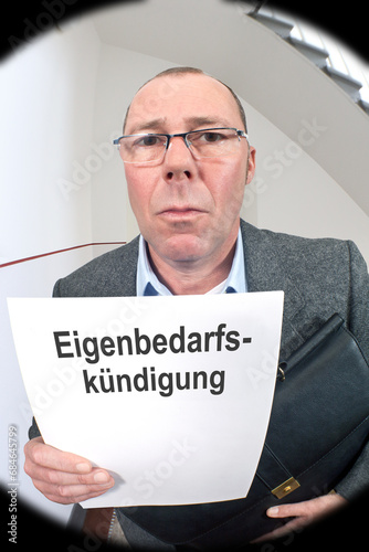 Blick durch den Türspion:Vermieter vor der Wohnungstüre mit Kündigungsschreiben wegen Eigenbedarf