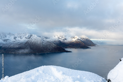 Aerial drone photo of snowy mountain hike up Segla in Senja, Norway. Snowcapped mountains in the Arctic Circle of Northern Norway. Famous hike on Senja island. Shot in October