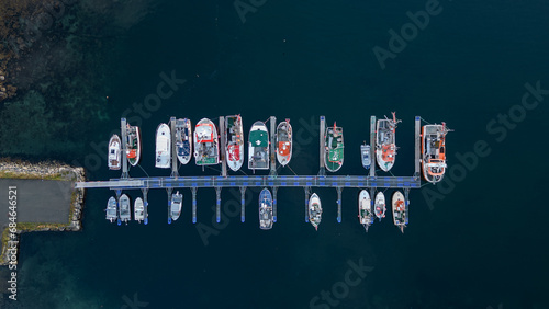 Aerial top down drone photo of the small island fishing town of Husoy on Senja, Norway.  A fishing village located in the Arctic Circle of Northern Norway.  Shot with a drone photo